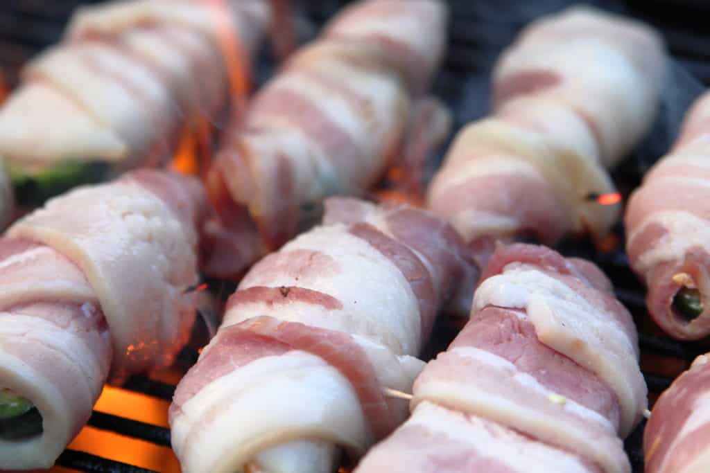 Bacon wrapped jalapeños on the grill

