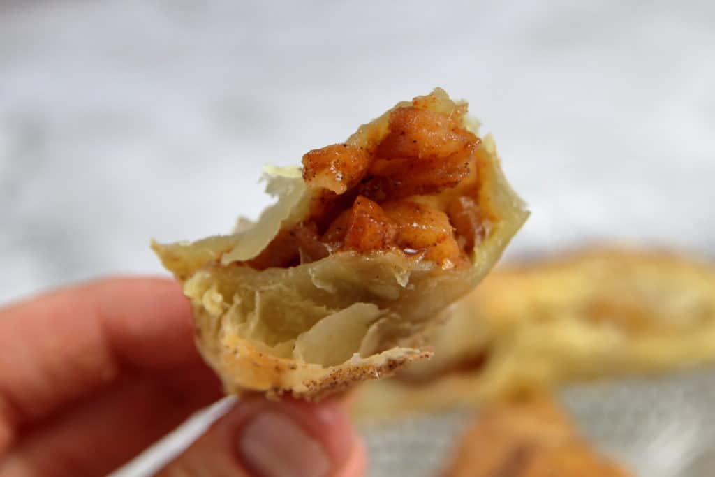 Puff pastry apple pie bite broken open with gooey filling