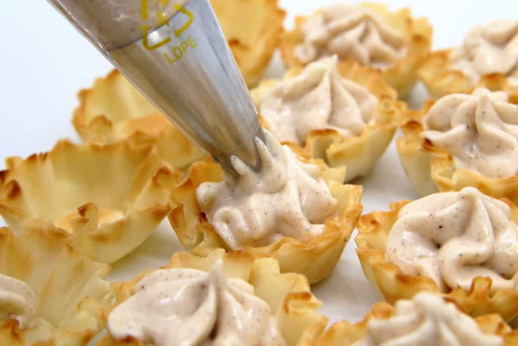 piping cheesecake filling into the phyllo shells