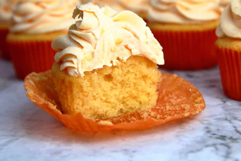 Orange Creamsicle Cupcake with a bite taken out to reveal the center