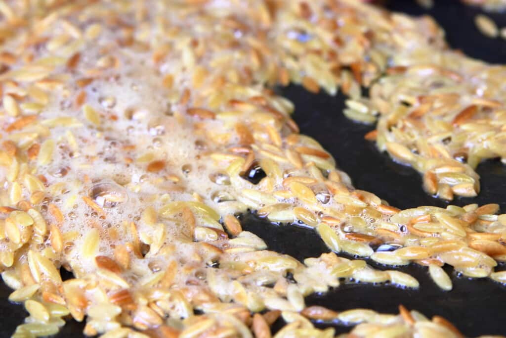 orzo toasting in butter in a saute pan.