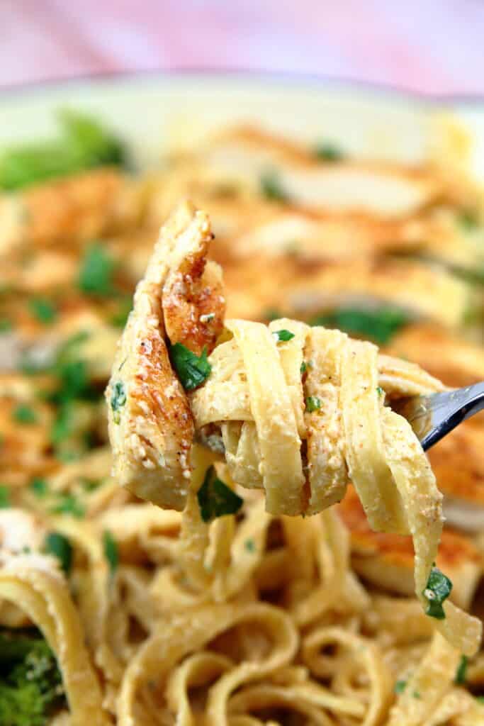 Cajun chicken pasta twirled up on a fork.