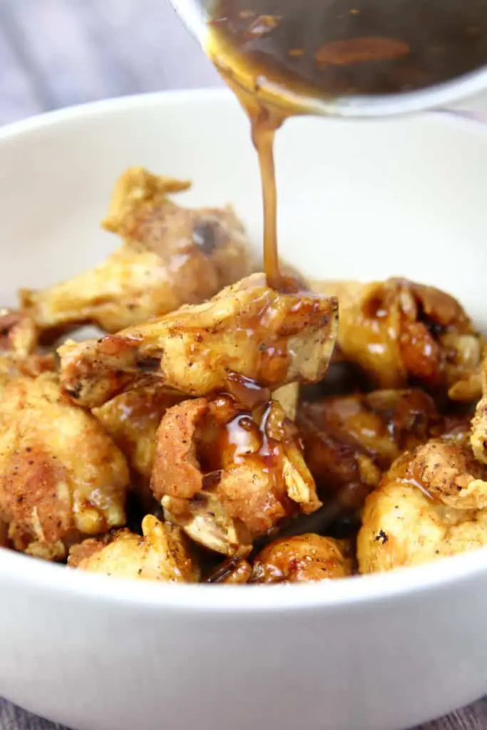 Pouring the sauce over the fried wings