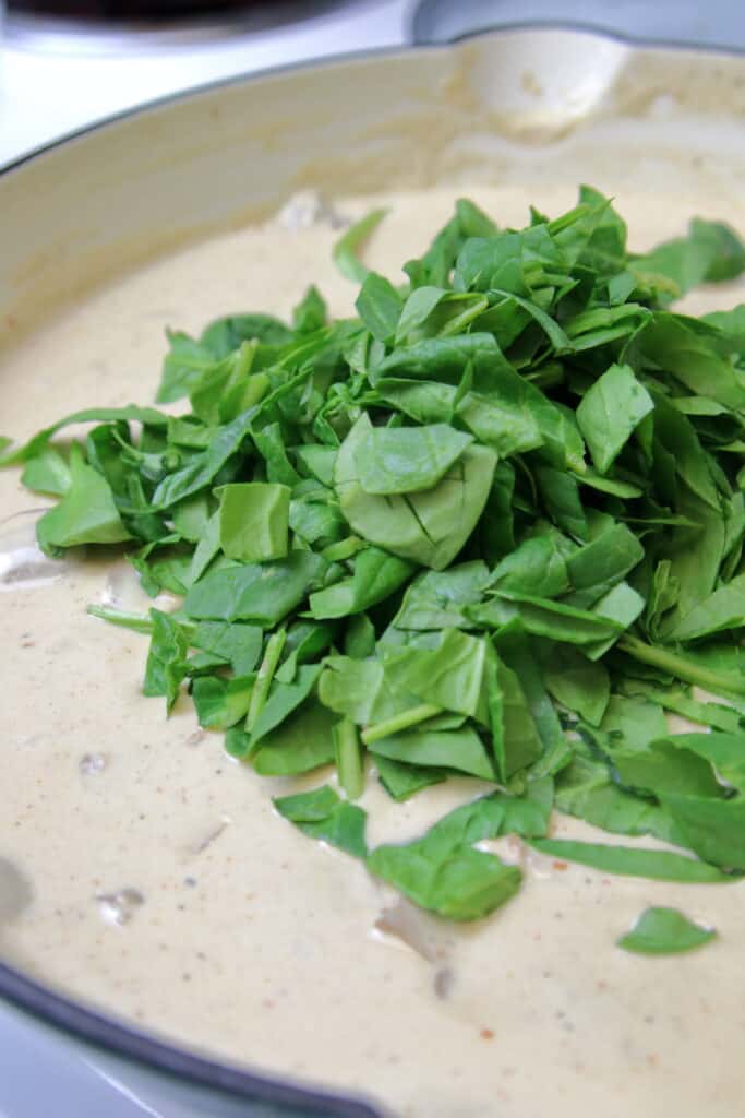Cream sauce with fresh spinach just added