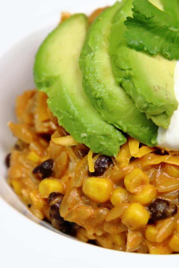 cheesy chicken enchilada bowl with sliced avocado