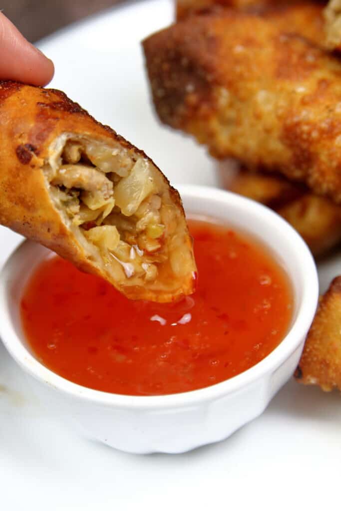 Pork Egg rolls cut in half and dipped in thai sweet chili sauce