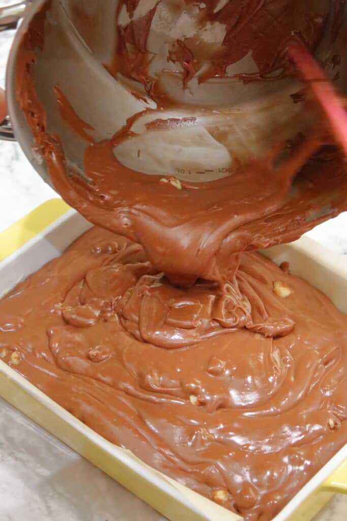 pouring melted homemade fudge in a prepared pan