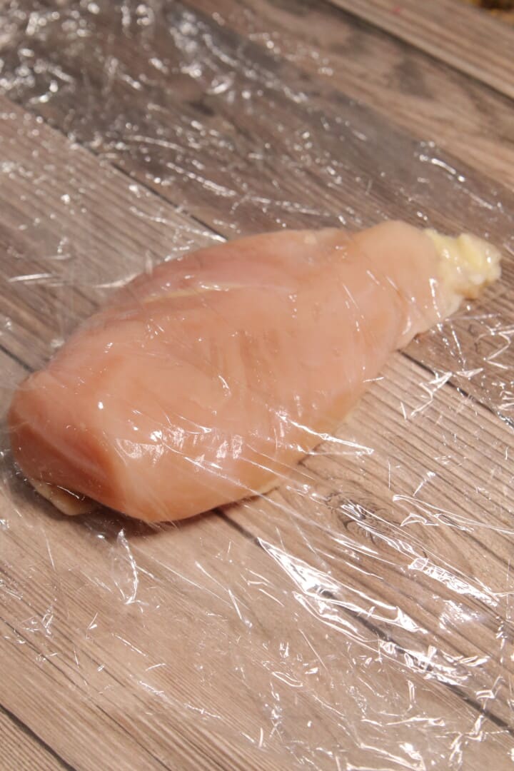 Chicken Breast between 2 pieces of plastic wrap