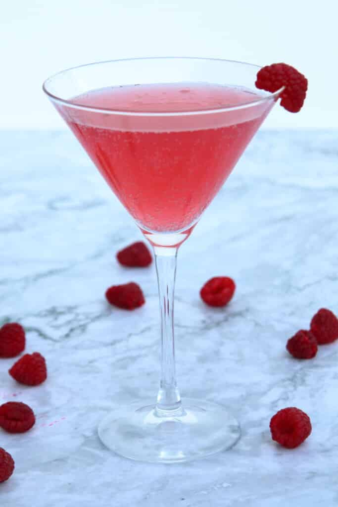 raspberry martini on a marble table with fresh raspberries