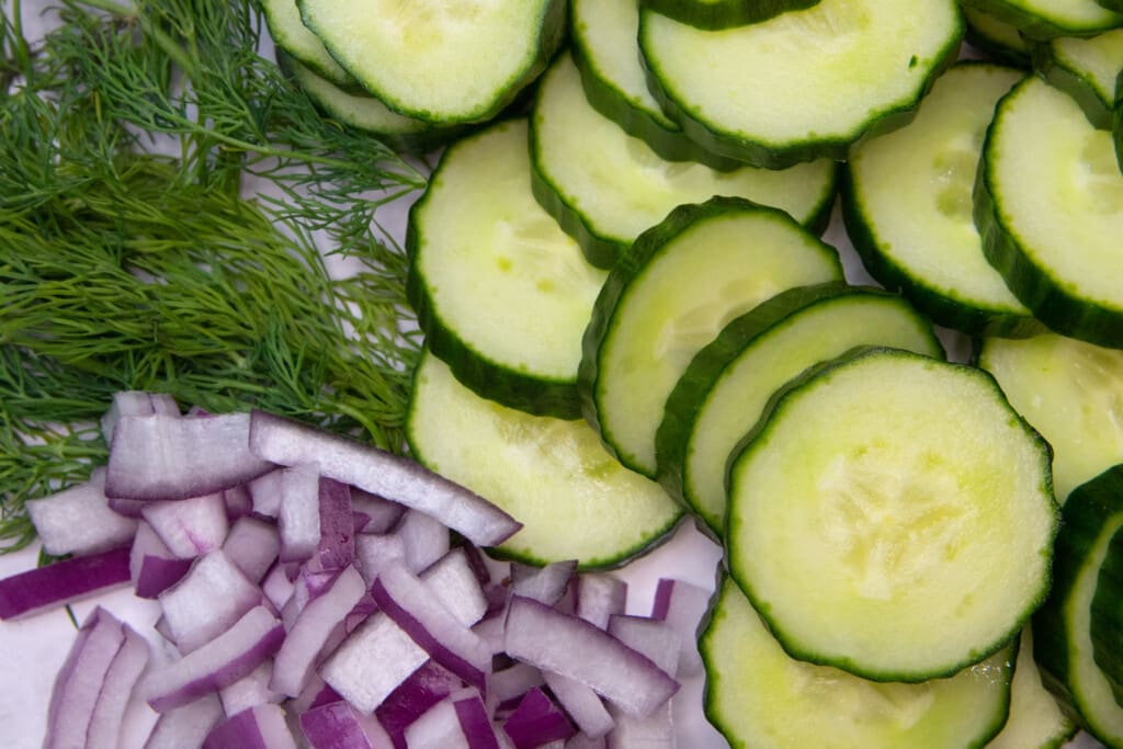 photo of cucumbers, fresh dill, and diced red onions