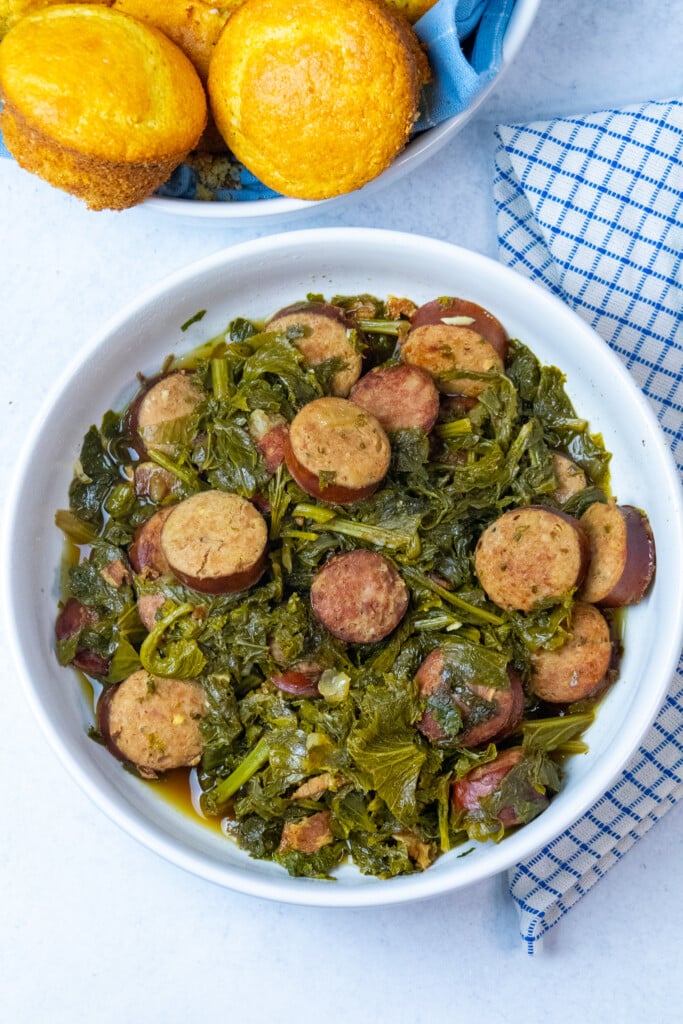 bowl of mustard greens with a bowl of cornbread on the side.