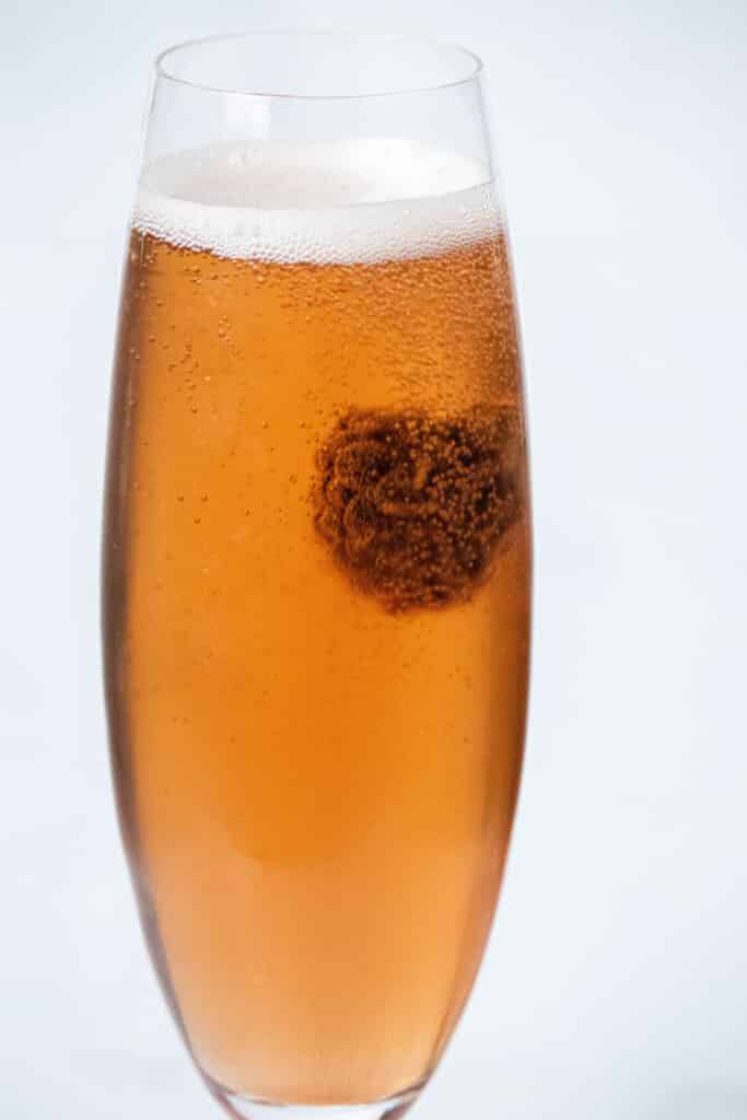 Close up of a kir royale with a bubble raspberry
